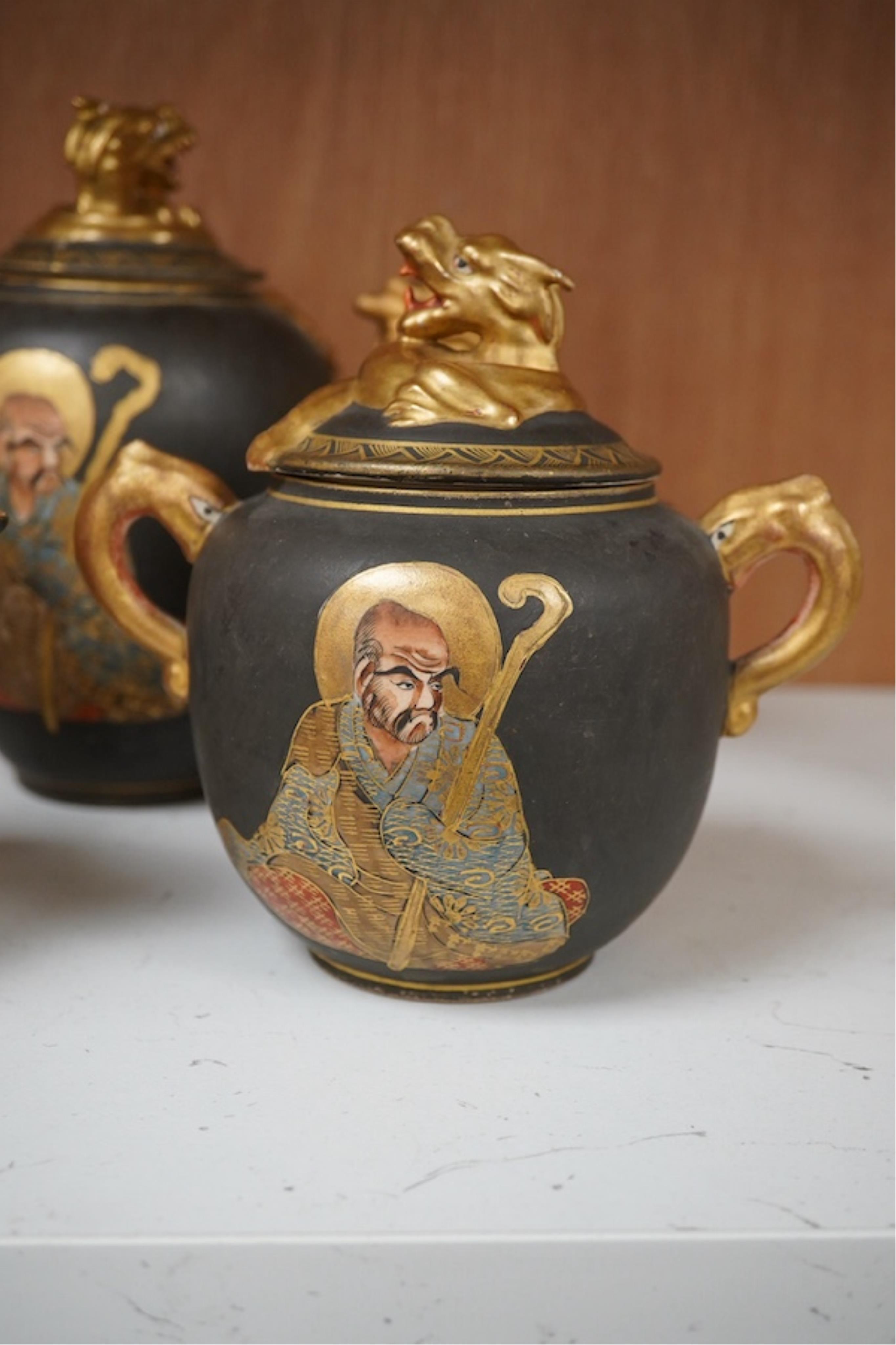 A Japanese Satsuma pottery enamel decorated tea set with Kwannon and rakan, teapot and cover 18cm high. Condition - one cup missing, one cup cracked